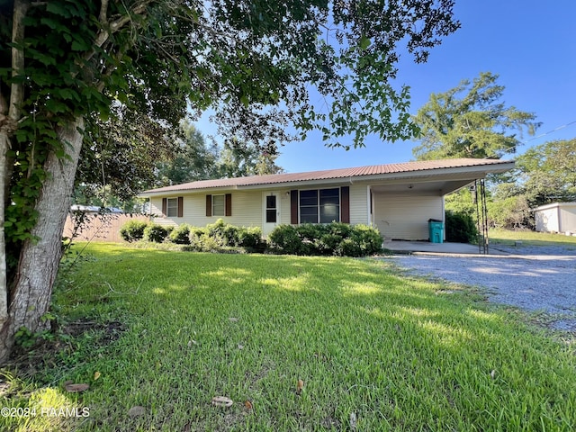 ranch-style house with a front yard and a carport