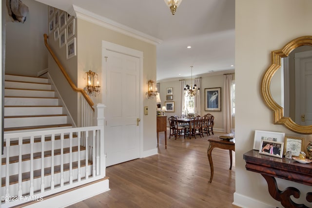 entryway featuring a chandelier, hardwood / wood-style flooring, and ornamental molding