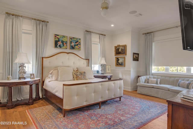 bedroom featuring hardwood / wood-style floors, ceiling fan, and ornamental molding