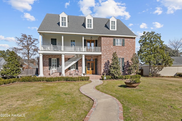 view of front of home featuring a balcony and a front lawn