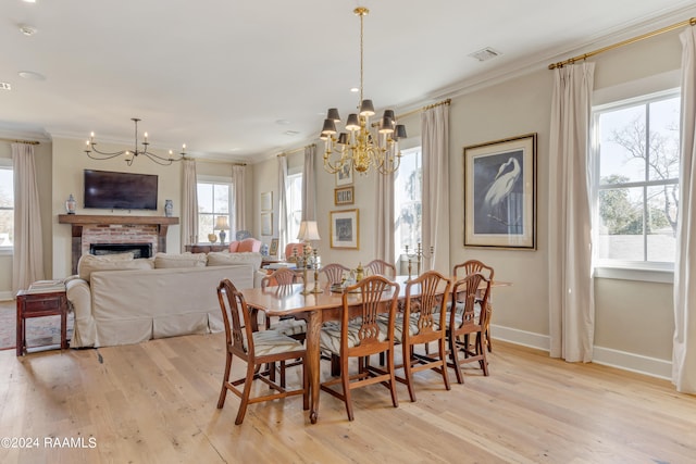 dining room with light wood-type flooring, ornamental molding, and a wealth of natural light