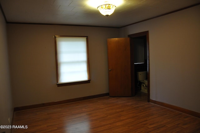 unfurnished bedroom featuring ornamental molding, baseboards, and wood finished floors