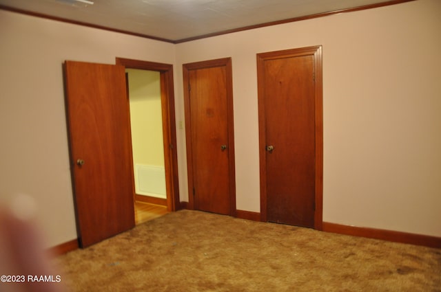 unfurnished bedroom with light colored carpet and crown molding