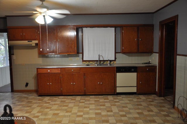 kitchen with a wainscoted wall, light countertops, a sink, a ceiling fan, and dishwasher