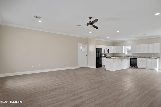 unfurnished living room featuring ornamental molding, light wood-type flooring, recessed lighting, and baseboards