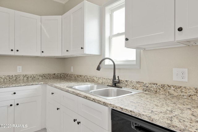 kitchen featuring black dishwasher, white cabinetry, and a sink