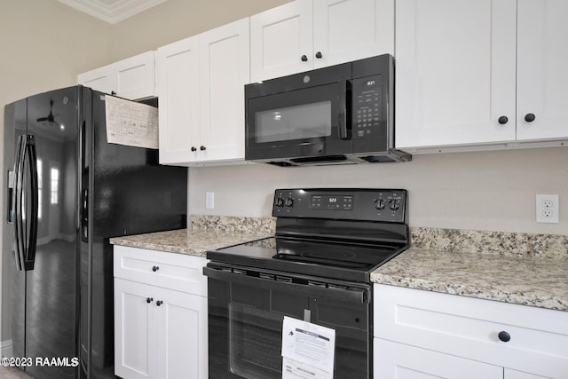 kitchen with ornamental molding, black appliances, light stone counters, and white cabinets