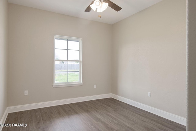 spare room featuring ceiling fan, baseboards, and dark wood-type flooring