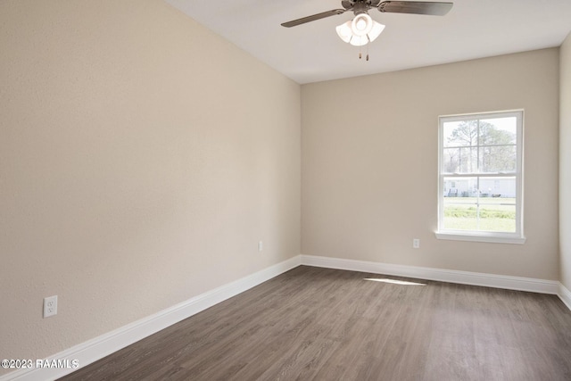 unfurnished room with a ceiling fan, baseboards, and dark wood-style flooring