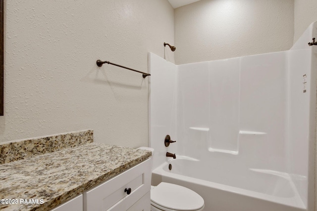 bathroom with a textured wall,  shower combination, and toilet