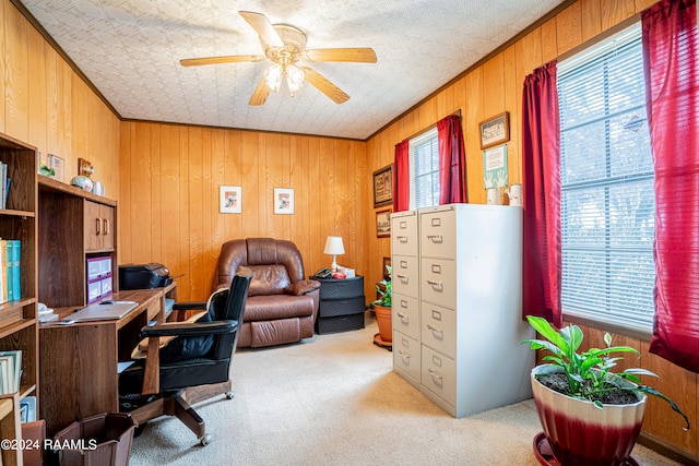 office featuring ornamental molding, wood walls, light colored carpet, and ceiling fan