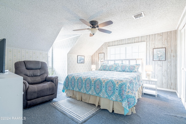 carpeted bedroom featuring a textured ceiling, ceiling fan, lofted ceiling, and wooden walls