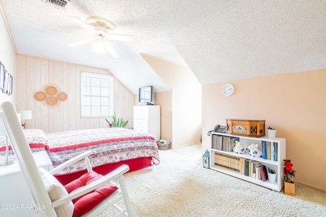 carpeted bedroom featuring vaulted ceiling, ceiling fan, and a textured ceiling