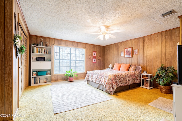 bedroom with ceiling fan, light carpet, and wooden walls