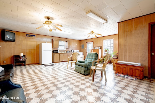 tiled living room featuring wooden walls and ceiling fan