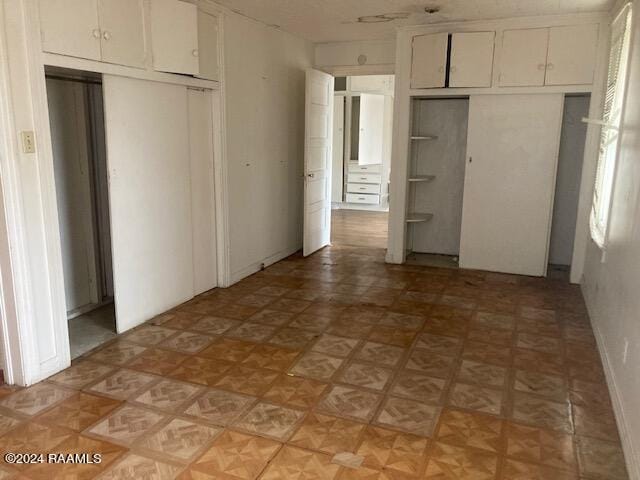 unfurnished bedroom featuring a closet and light parquet floors