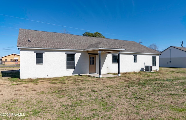 rear view of property with a patio, central AC, and a yard