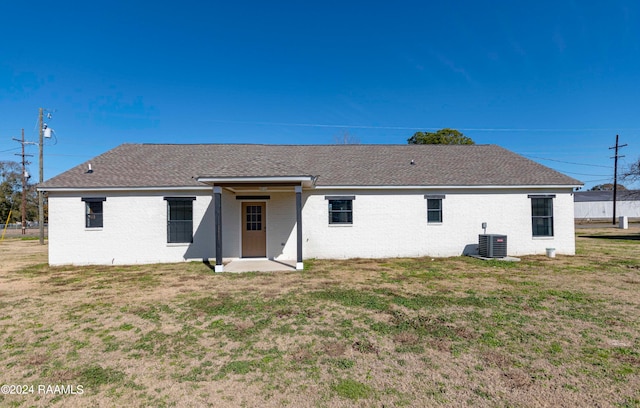 back of property with a yard and central AC unit