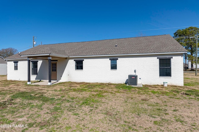 back of house featuring a lawn and central AC unit