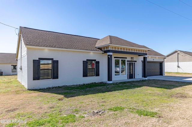 view of front of property featuring a front lawn and a garage