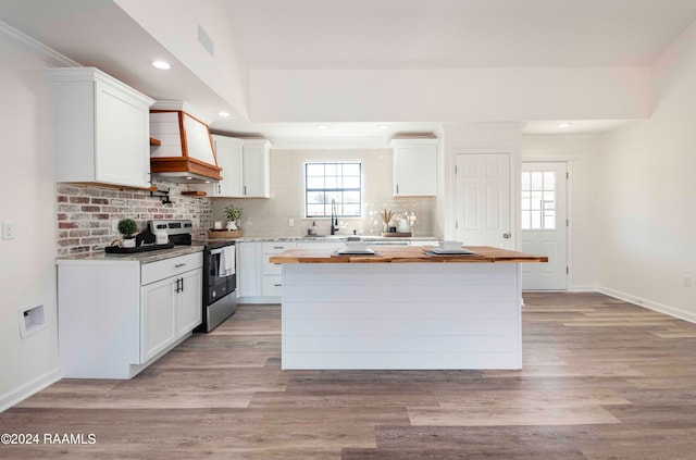 kitchen featuring white cabinets, a center island, and stainless steel electric range