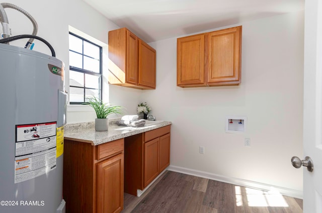 kitchen with dark hardwood / wood-style flooring, electric water heater, and light stone countertops