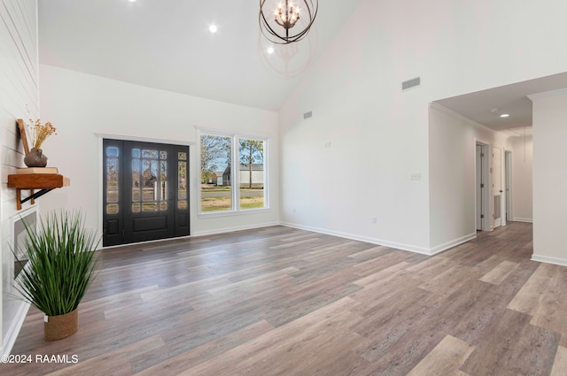 entrance foyer with a chandelier, high vaulted ceiling, and hardwood / wood-style flooring