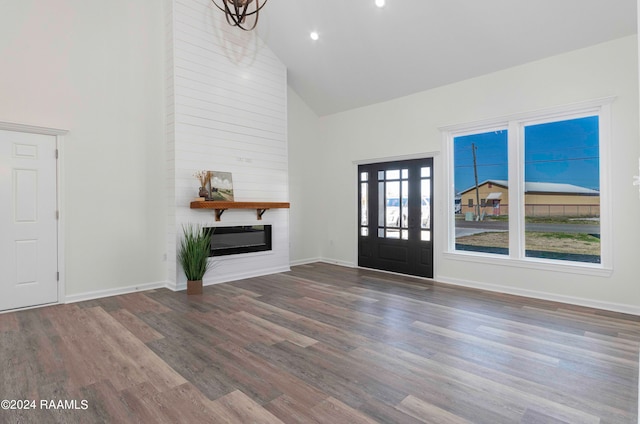 foyer featuring dark hardwood / wood-style flooring, a fireplace, and high vaulted ceiling