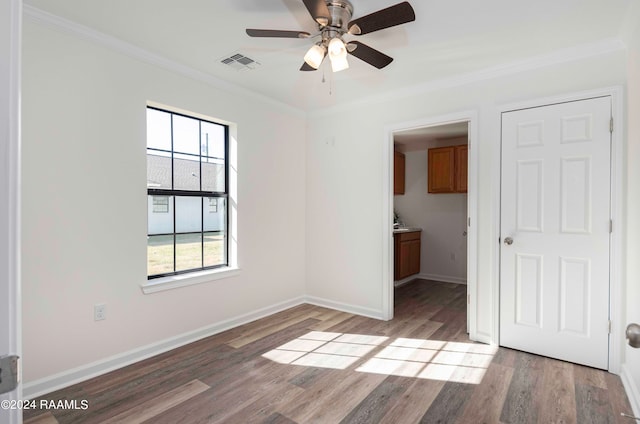 unfurnished bedroom with crown molding, a closet, ceiling fan, and dark hardwood / wood-style flooring