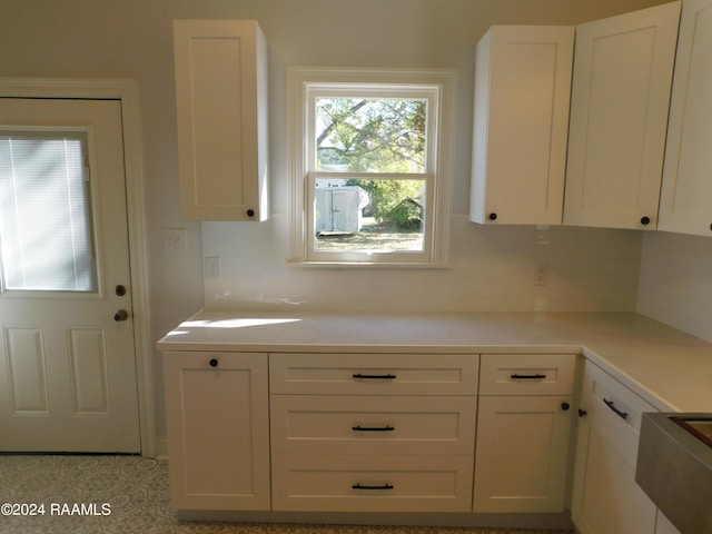 kitchen featuring tasteful backsplash and white cabinets