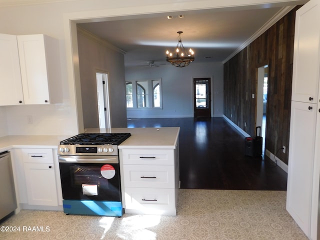 kitchen with appliances with stainless steel finishes, ornamental molding, white cabinets, and decorative light fixtures