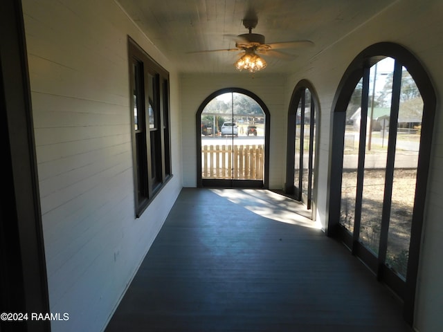 unfurnished sunroom with ceiling fan