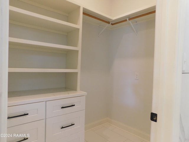 spacious closet with light tile floors