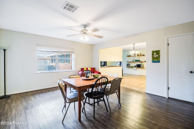 dining area featuring dark hardwood / wood-style floors and ceiling fan with notable chandelier