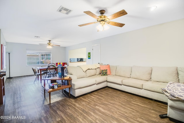 living room featuring ceiling fan and dark hardwood / wood-style floors