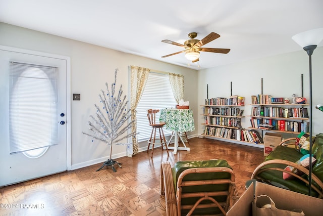 sitting room with ceiling fan and light parquet floors