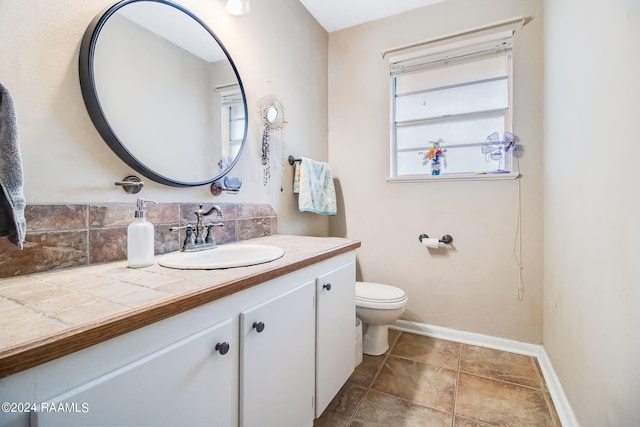 bathroom with backsplash, toilet, vanity, and tile flooring