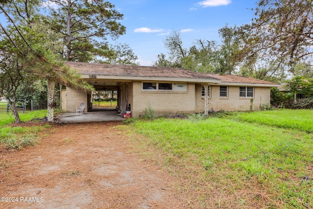 ranch-style house with a front yard and a carport