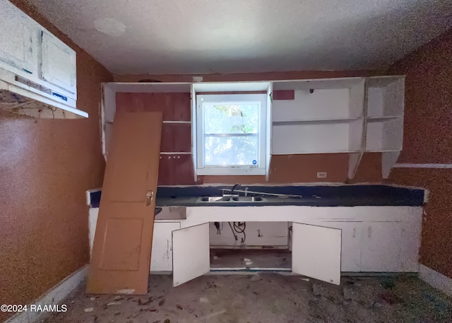 kitchen featuring a textured ceiling and sink