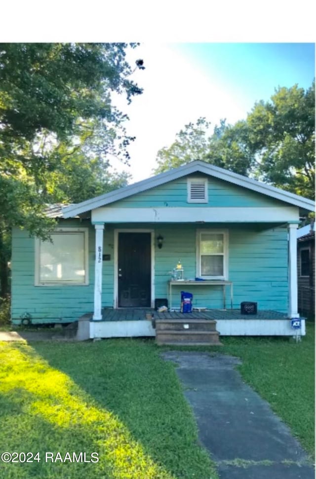 bungalow with a front yard and a porch