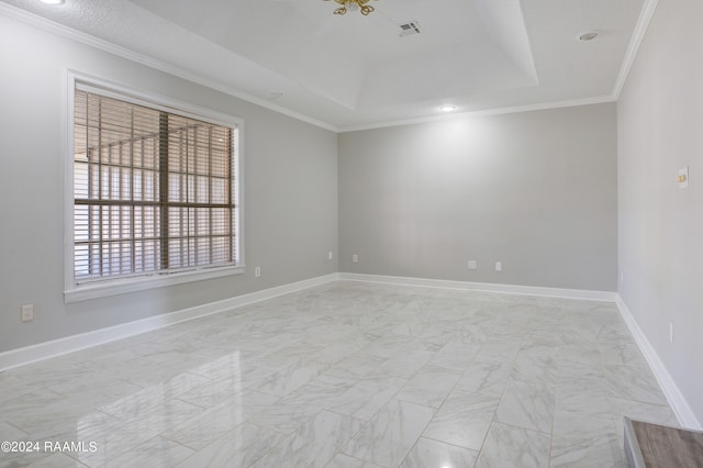 spare room featuring a tray ceiling, light tile floors, and crown molding