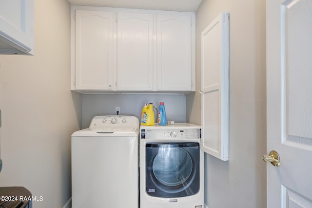 washroom with washer and clothes dryer and cabinets