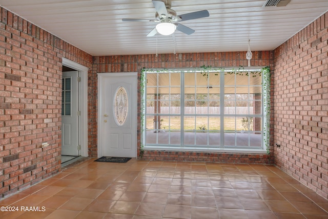 unfurnished sunroom with ceiling fan