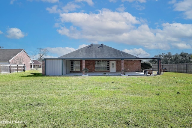 back of property with a patio area and a yard