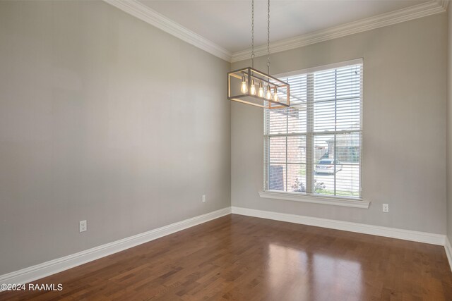 unfurnished room with a notable chandelier, crown molding, and dark wood-type flooring