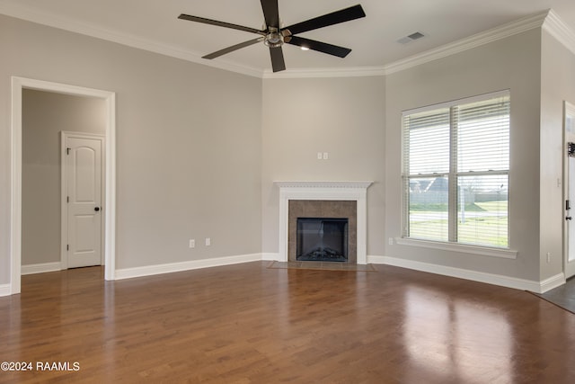 unfurnished living room featuring a tiled fireplace, crown molding, ceiling fan, and dark hardwood / wood-style flooring