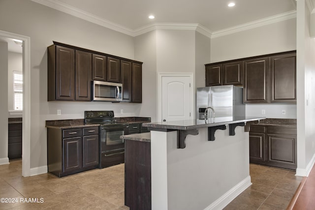 kitchen with an island with sink, a breakfast bar area, stainless steel appliances, light tile floors, and dark brown cabinetry