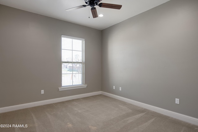 carpeted spare room with ceiling fan