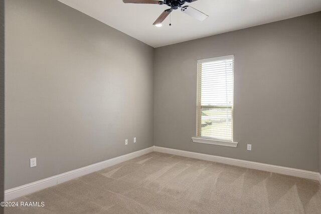 carpeted spare room with plenty of natural light and ceiling fan