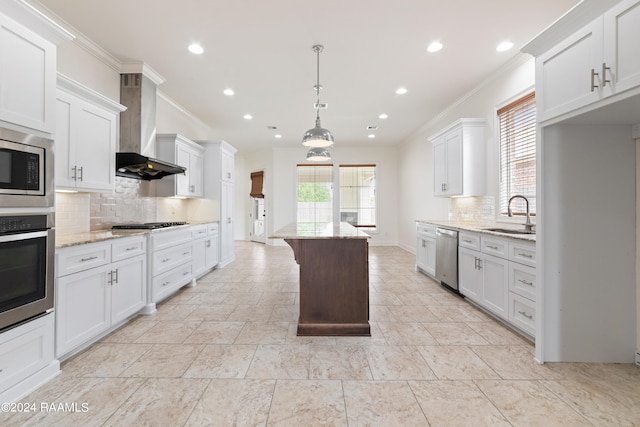 kitchen featuring white cabinets, stainless steel appliances, and wall chimney range hood